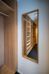 Walk-in-closet i lys egetræ med håndbygget spejl