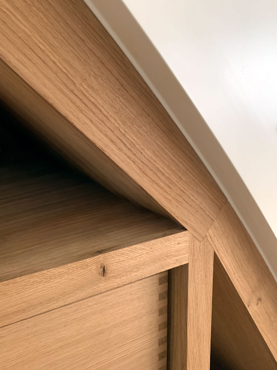 Præcis fuge mellem hvid trappe og massiv egetræsramme på indbygget opbevaring under trappe