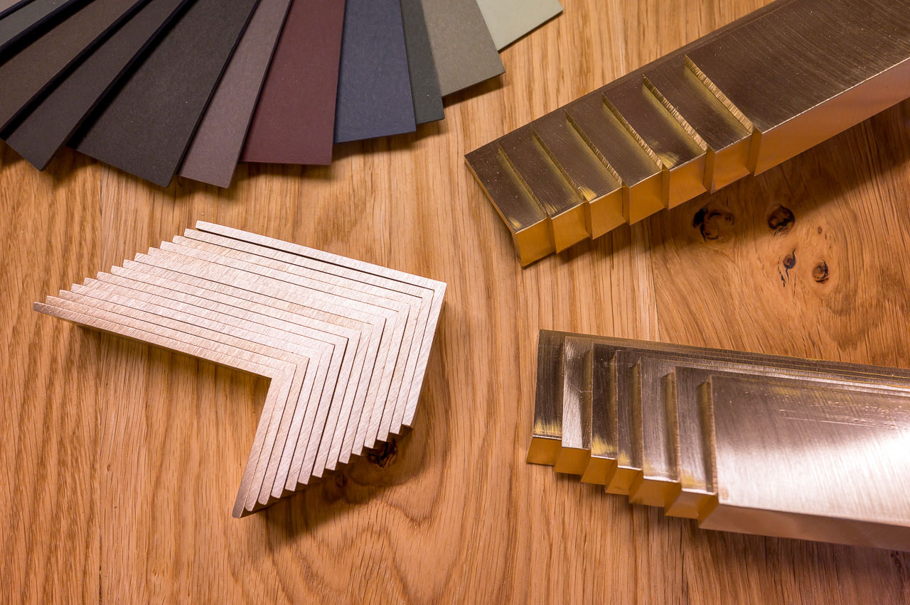 Materialeprøver: massiv egetræ, grøn Forbo linoleum Conifer og håndlavede slebne messinggreb – præcis de materialer brugt i opbevaringen under trappe