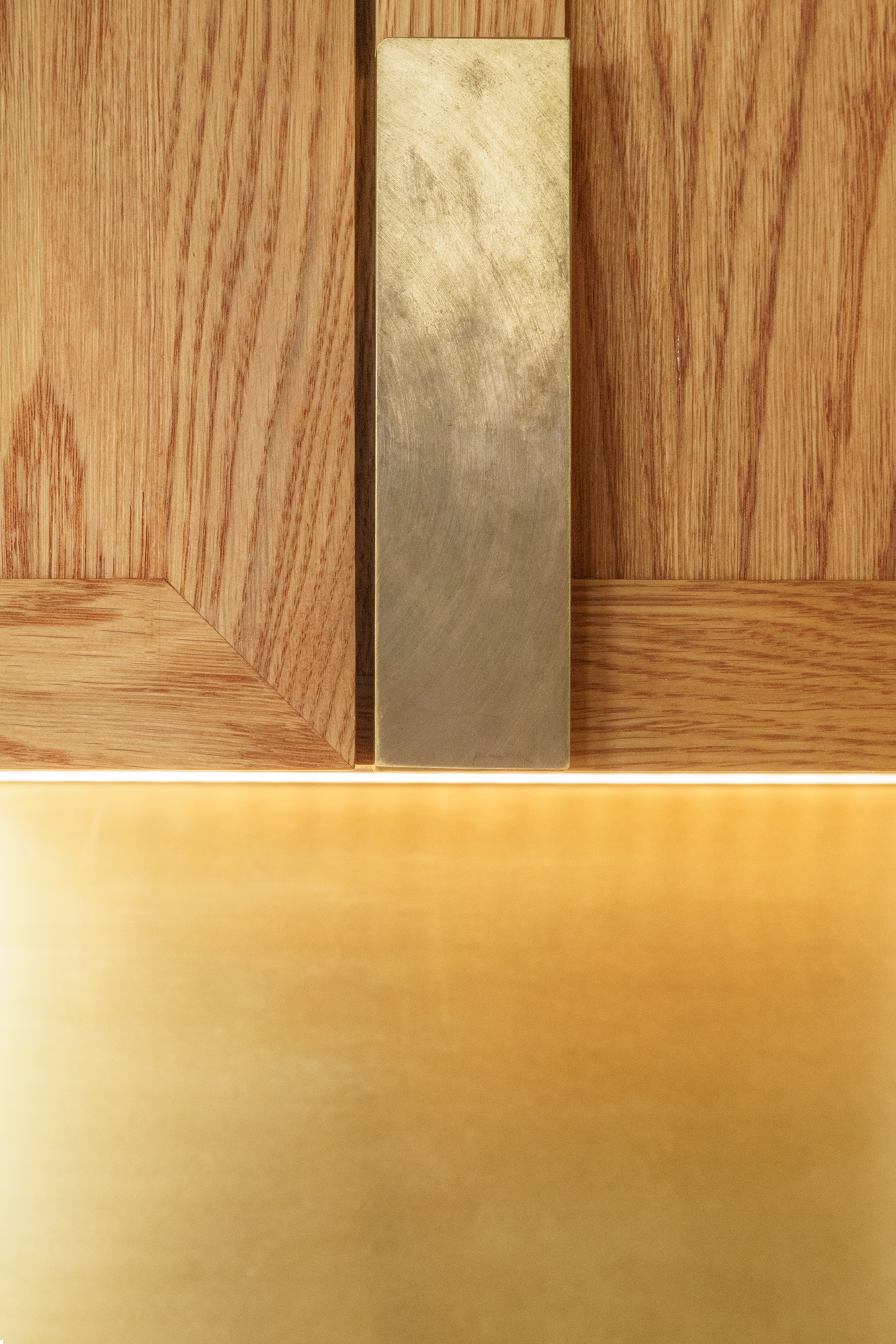 Nærbillede messinggreb på et overskab, messingbagplade