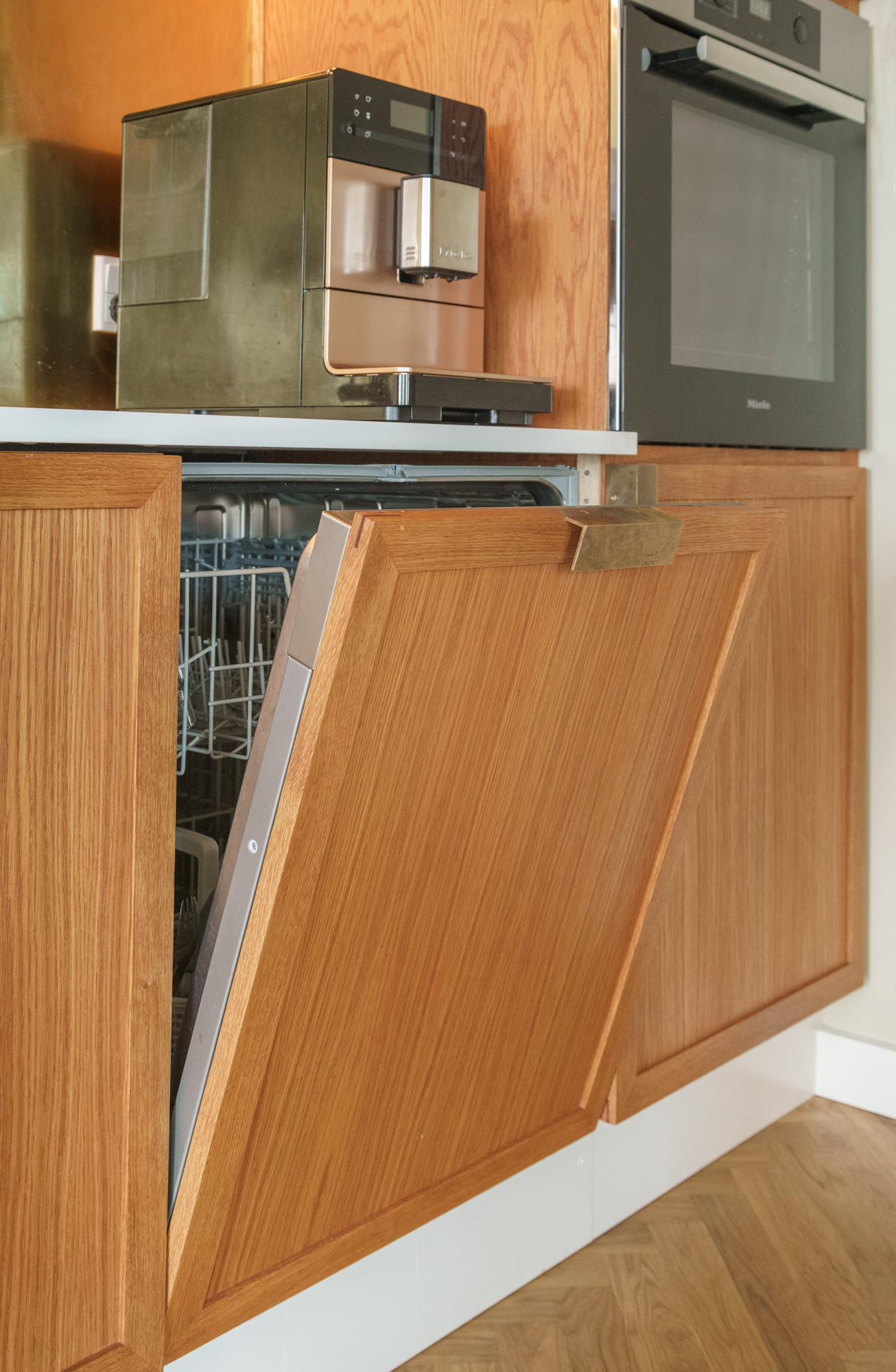 Opvaskemaskine fra siden, Miele kaffemaskine og ovn i baggrund