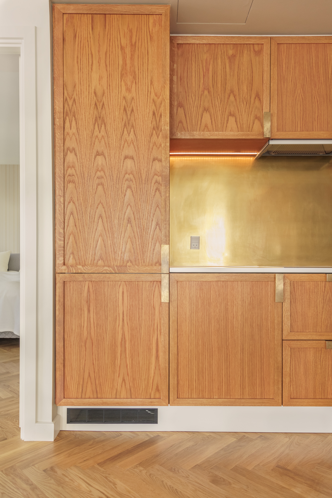 Venstre side – køl/frys-højskab, overskabe, emhætte, sildebensgulv