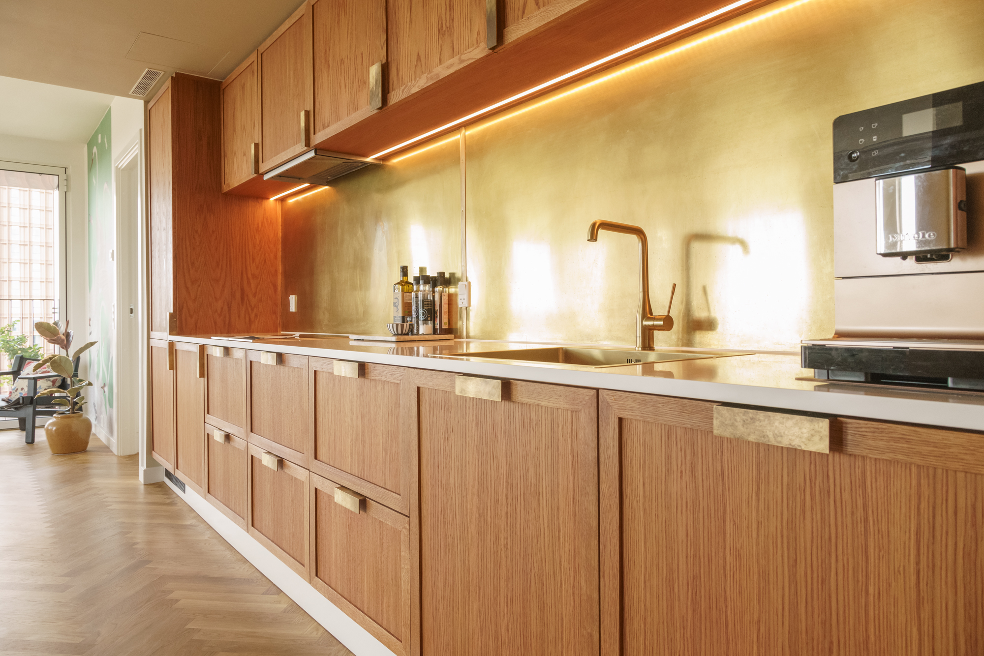 Perspektiv langs bordplade – LED, messingbagplade reflekterer lys, vandhane